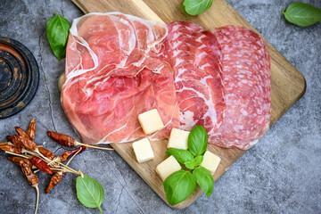 Slices Of  Traditional Italian antipasti mortadella Bolognese,salame Milano, parmesan cheese  and prosciutto crudo   on a wooden  cutting board.