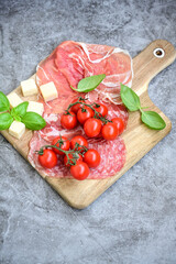 Slices Of  Traditional Italian antipasti mortadella Bolognese,salame Milano, parmesan cheese  and prosciutto crudo   on a wooden  cutting board.