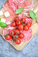 Slices Of  Traditional Italian antipasti mortadella Bolognese,salame Milano, parmesan cheese  and prosciutto crudo   on a wooden  cutting board.