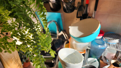 A mess in the kitchen. Dirty dishes around the sink. The concept of advertising cleaning service, displaying the routine after the party, holiday.