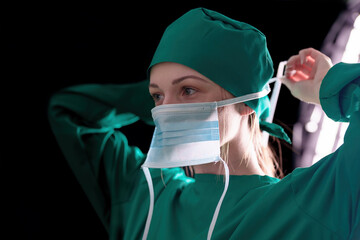 Doctor surgeon preparing makes an operation. Isolated on a black background.