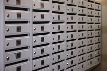 Backdrop of white Mailboxes in an apartment residential modern building. Background of rows of...
