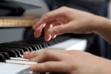 two hands playing the  black piano