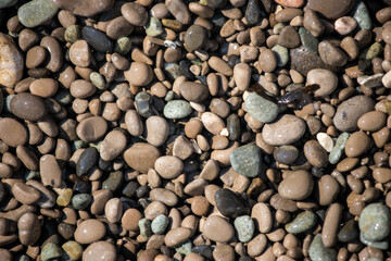 Small pebbles of gray color, gravel. Sea beach texture background