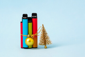 A set of colorful disposable electronic cigarettes are packaged as a Christmas present on blue...