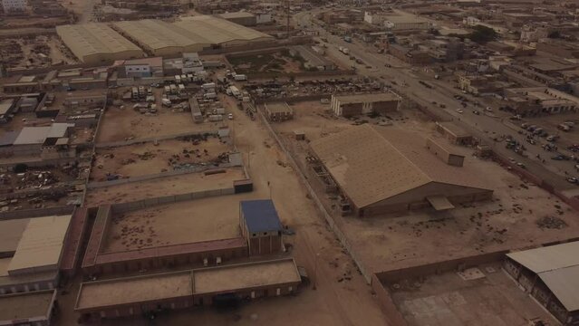 An drone reveal shot moving backwards showing the buildings of the commercial port in Nouakchott, Mauritania.