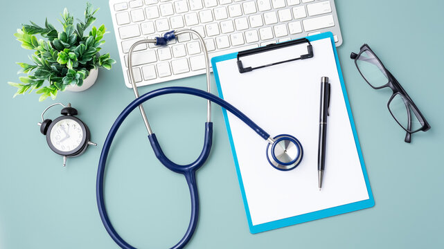 Doctor Desk With Stethoscope And Computer Keyboard On Blue Background