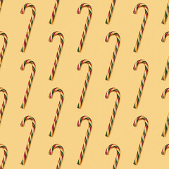 Christmas seamless pattern made with striped candy canes on yellow background