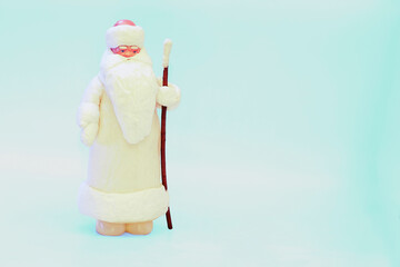 Santa claus with staff in white fur coat isolated on snow blue
