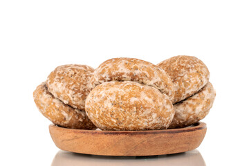 Several sweet tasty gingerbread cookies on a wooden plate, macro, isolated on white background.