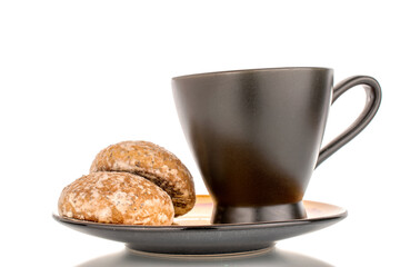 Two sweet delicious gingerbread cookies with black ceramic cup on ceramic plate, macro isolated on white background.