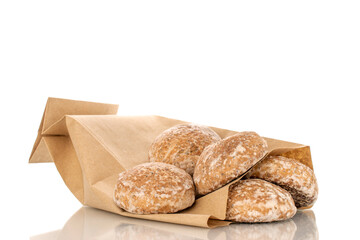 Several sweet tasty gingerbread cookies with paper bag, macro, isolated on white background.