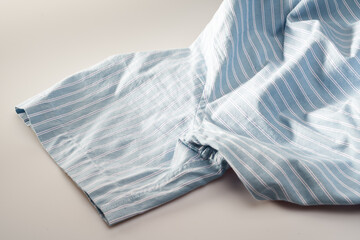 Partial closeup of a light blue striped shirt