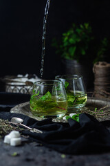 herbal, mint tea with splashes on a dark background