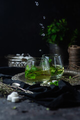 herbal, mint tea with splashes on a dark background