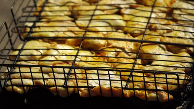 close-up of flattened out barbecued golden crispy skin chicken tabaka on grid, side view from above