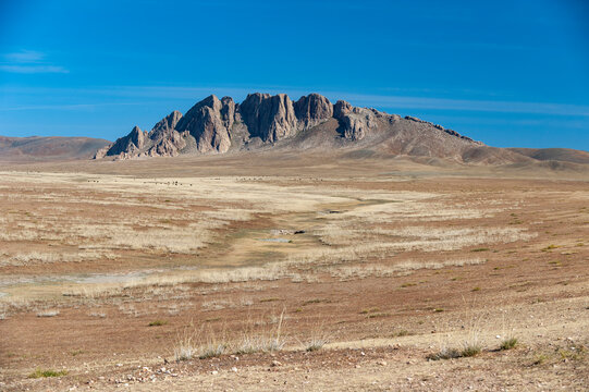 Felsformation am Horizont in der Steppenlandschaft der Wüste Gobi, Mongolei, Zentralasien
