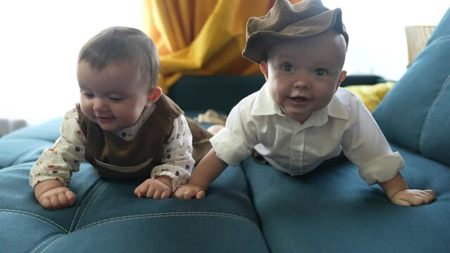 twin babies in retro clothes. brother and sister a twins kids sit on the couch in lifestyle retro clothes cap play among themselves. happy family kid dream twin concept