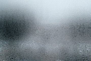 Textured surface of wet misted window glass on cloudy foggy day