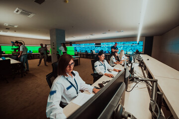 Group of female security operators working in a data system control room Technical Operators Working at workstation with multiple displays, security guards working on multiple monitors in surveillan