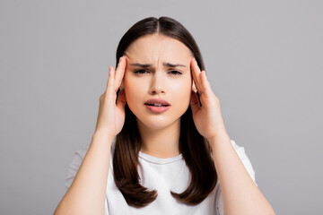 Fototapeta premium Young beautiful girl woman lady in white t-shirt with hand on head, headache because of stress. suffering migraine.