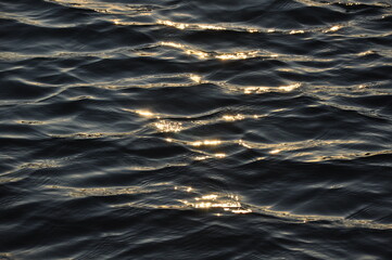 ripples on the water at sunset with sunlight reflection