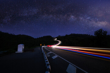  long exposure shot  car light at night scene blue sky and galaxy or star milky way background, at...