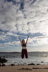 Woman Jumping In The Air On Beach