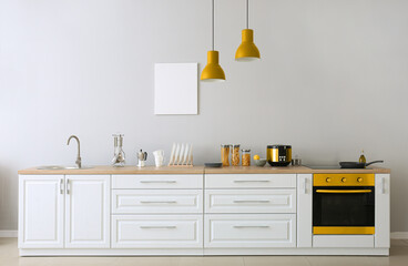 Interior of light kitchen with modern yellow oven
