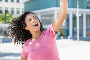 Cheering hispanic young adult woman