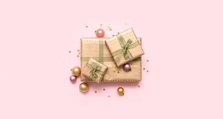 Gift boxes with Christmas balls on pink background