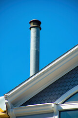 Light metal chimney vent on gable style roof with black accent top and white paint edges of roof...