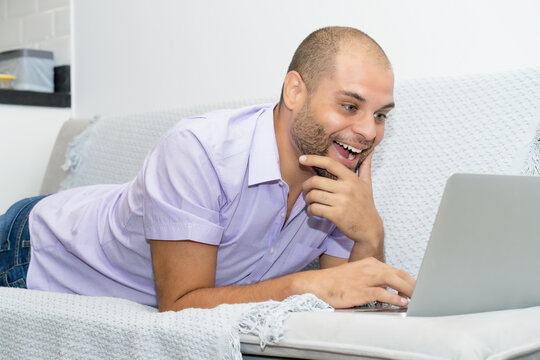 Handsome man with bald and beard streaming movie at computer