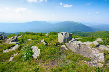 Fototapeta na wymiar carpathian countryside in summer. mountain landscape with view in to the distant ridge and alpine valley. stones on the grassy meadow in the afternoon light