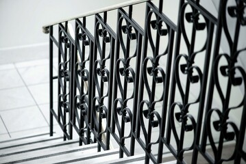 Closeup of the stairs with decorative metal handrails. - obrazy, fototapety, plakaty