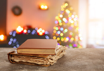 Old books on table in room decorated for Christmas