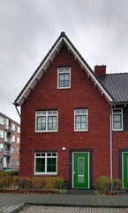 Fototapeta na wymiar Red brick house with green door