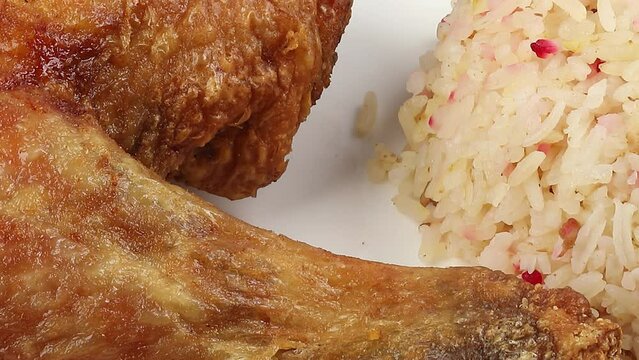 Indonesian royal dish nasi bojari with deep spiced deep fried chicken leg sambal prawn curry beef rendang boild egg cucumber and tomato slice