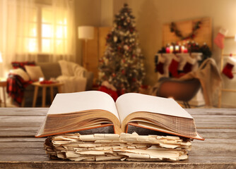 Old books on table in room decorated for Christmas