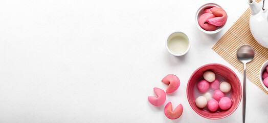Obraz na płótnie Canvas Bowls of tasty tangyuan and fortune cookies on white background with space for text. Dongzhi Festival