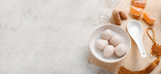 Bowl of tangyuan, fortune cookie and mandarins on grunge background with space for text. Dongzhi...