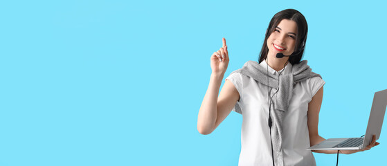 Female technical support agent holding laptop on light blue background with space for text