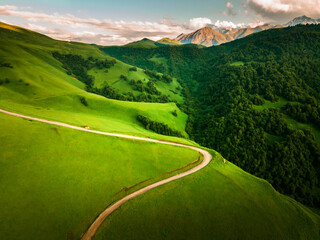 Road in the green mountains at sunset. Aktoprak Pass in North Caucasus, Russia.