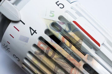 Thermostat of an heating radiator with euro banknotes.