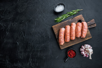 Traditional raw pork sausages, flat lay with space for text, on black background