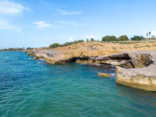 Fototapeta na wymiar The coastline of Cyprus in the Paphos region. Eroded rocks and sea caves