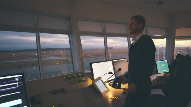Surveillance oficer with binoculars control airport traffic in tower. Realtime