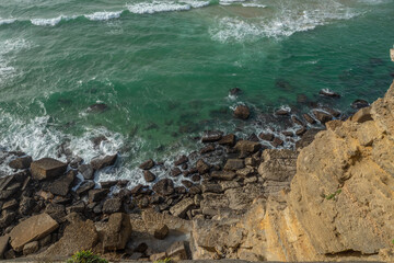 Ocean waves approaching rocky shore. Top view.