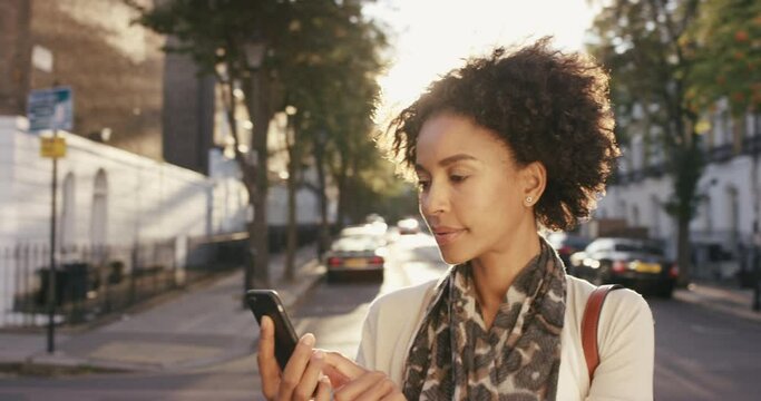 Street, smartphone and black woman location search, social media update and map app information. Typing, check and road of girl on cellphone for social networking in London urban city with lens flare