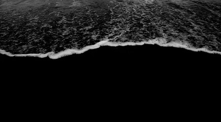 Fototapeta na wymiar black and white waves on beach 